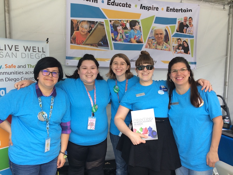 The Library outreach team poses for a picture at a previous STEM Festival event where they shared about robots and 3D printing.